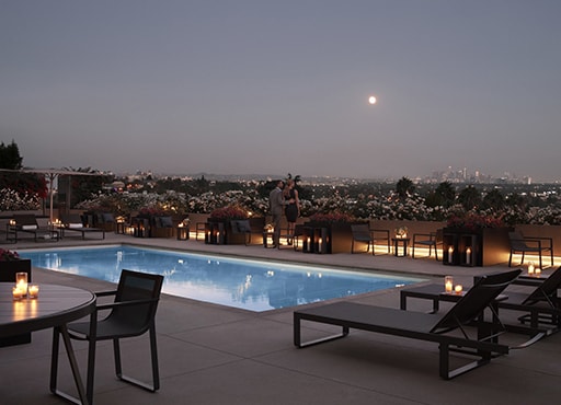 Large ooudoor pool with views of Los Angeles at dusk