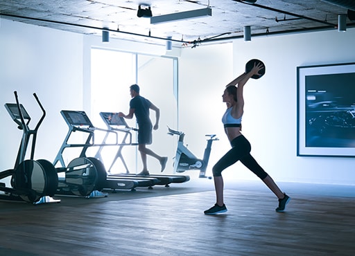 Woman excersizing in a fitness center with treadmills and weights