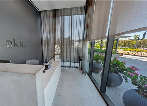 Inviting lobby with floor to ceiling windows showing outdoor flower pots