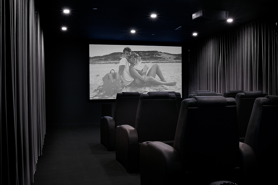 Empty indoor cinema with theater seats showing a movie