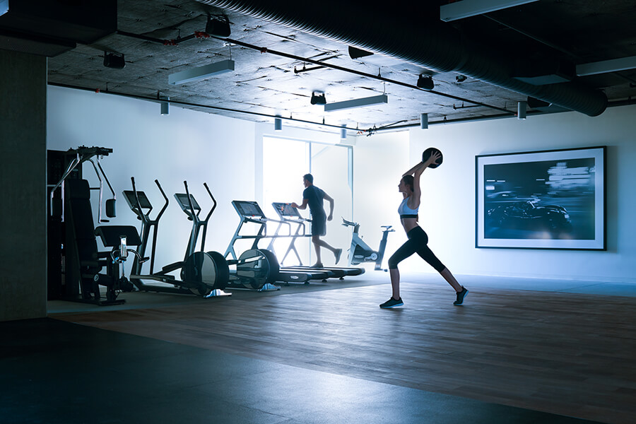 Woman exercising in a fitness center with treadmills and weights