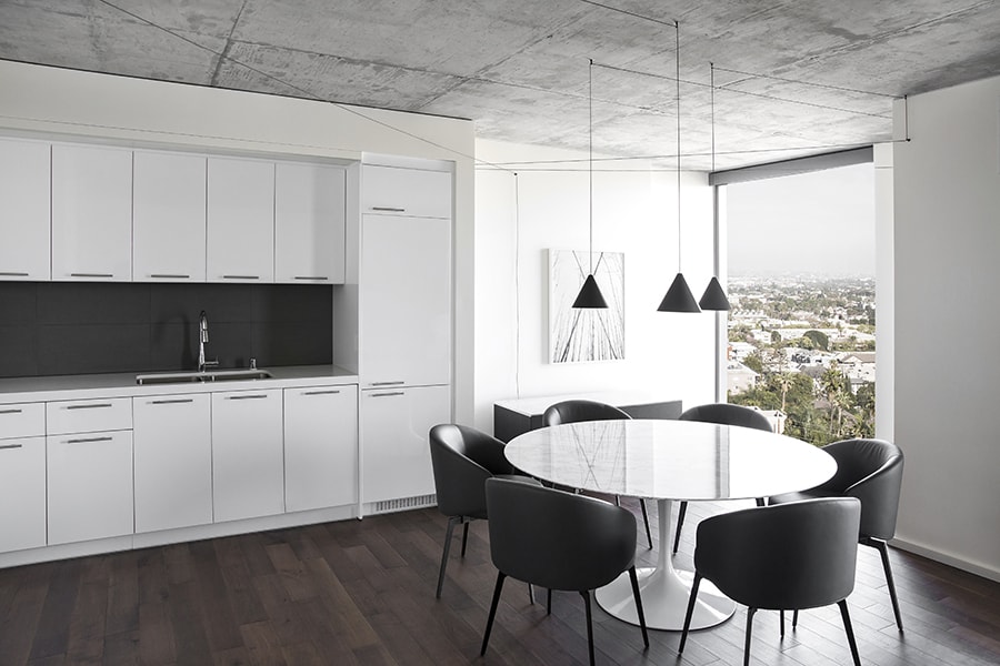 WeHo kitchen with white cabinets and a dining table at AKA West Hollywood